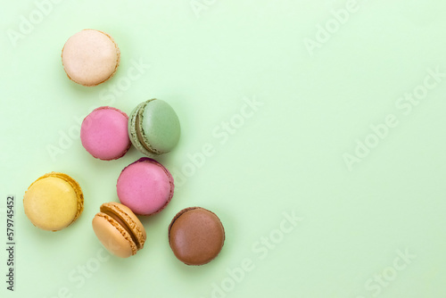 Colored macarons on a pastel green background