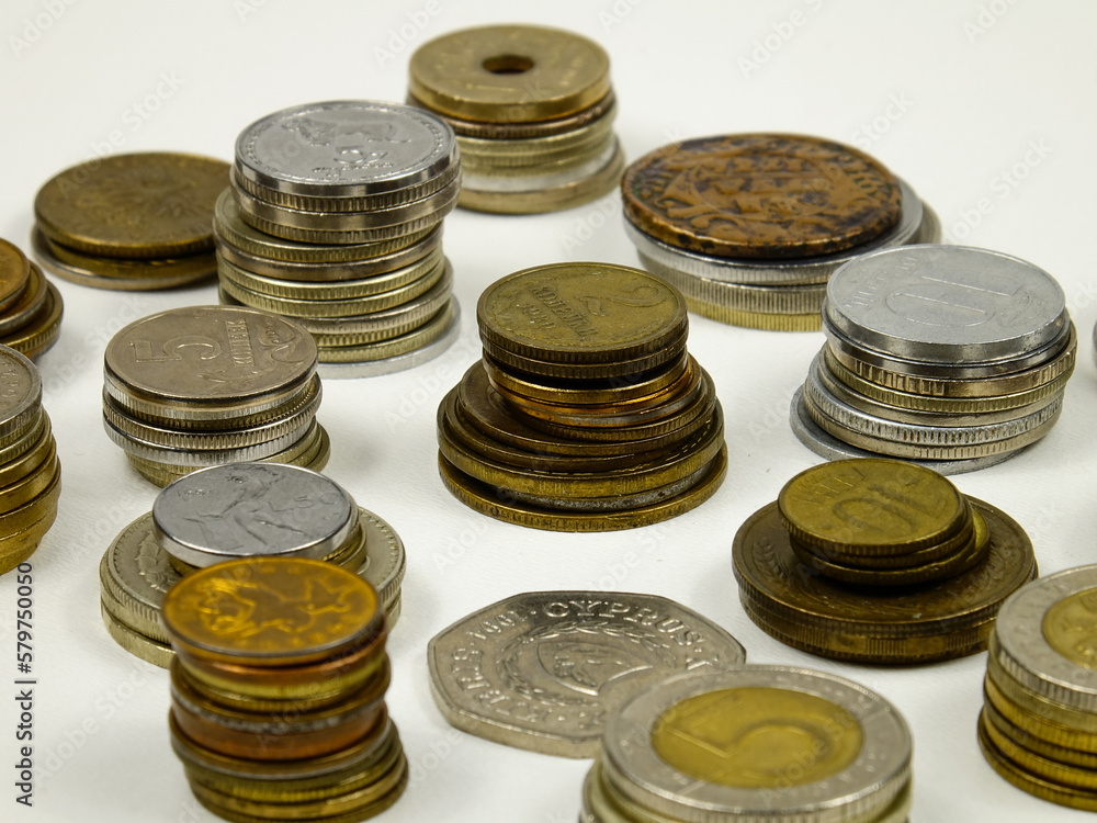 Old and modern coins stacked in the piles on a white table, background
Old and modern coins stacked in the piles on a white table, background