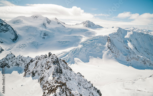 Alpine panorama in winter from Pitztal Glacier, Austria. Oetztaler Wildspitze, Weisskamm, Tyrol, Austria. Mountains covered with snow in ski resort photo