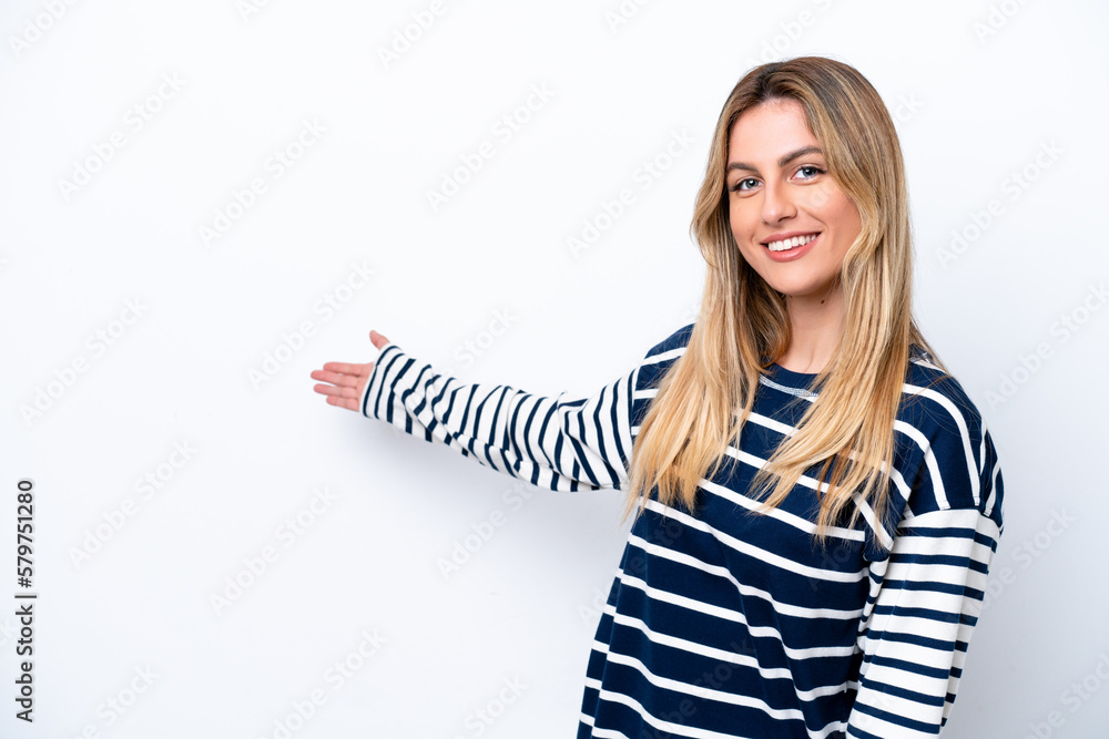 Young Uruguayan woman isolated on white background extending hands to the side for inviting to come Young Uruguayan woman isolated on white background extending hands to the side for inviting to come