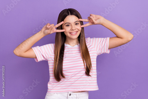 Photo of charming adorable girl dressed striped t-shirt showing two v-signs cover eyes isolated purple color background © deagreez