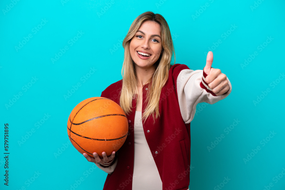 Young caucasian basketball player woman isolated on blue background with thumbs up because something good has happened Young caucasian basketball player woman isolated on blue background with thumbs up because something good has happened