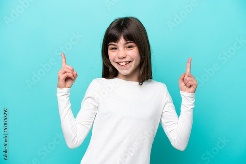 Little caucasian girl isolated on blue background pointing up a great idea