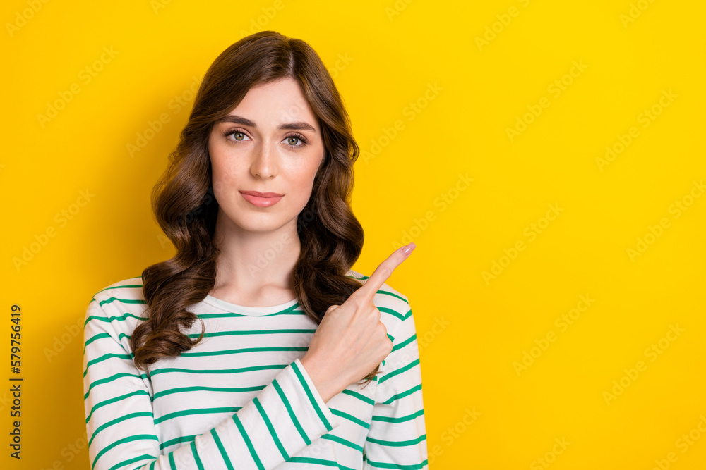 Photo of young serious business lady brown wavy hair wear stylish striped shirt indicate finger empty space isolated on yellow color background Photo of young serious business lady brown wavy hair wear stylish striped shirt indicate finger empty space isolated on yellow color background