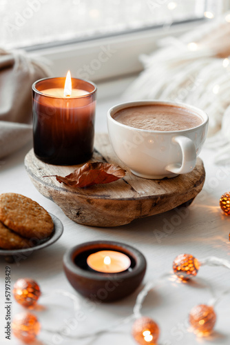  warm cozy window arrangement, winter or autumn concept, coffe, candles throw lights