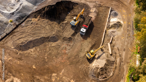 Aerial view of a stone and sand quarry. Trucks are loading material for transformation into gravel and cement production. Industrial concept.