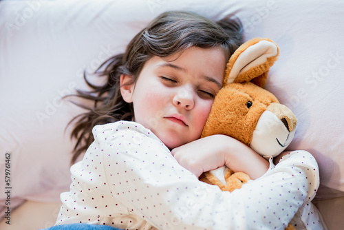 Adorable girl sleeping with plush toy photo