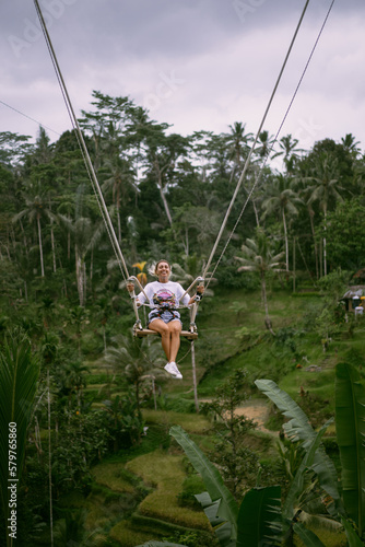 Young woman swinging in the jungle rainforest of Bali island, Indonesia. Swing in the tropics.