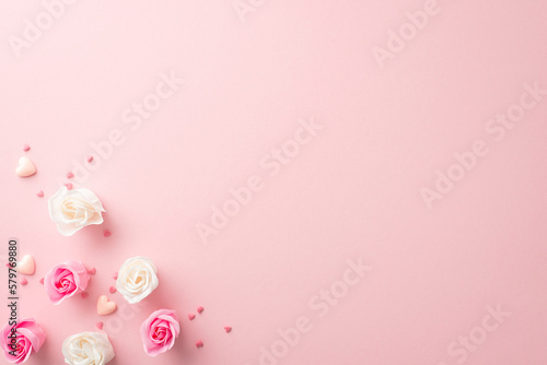 Mother's Day atmosphere concept. Top view photo of white and pink rose buds small hearts and sprinkles on isolated pastel pink background with copyspace © ActionGP