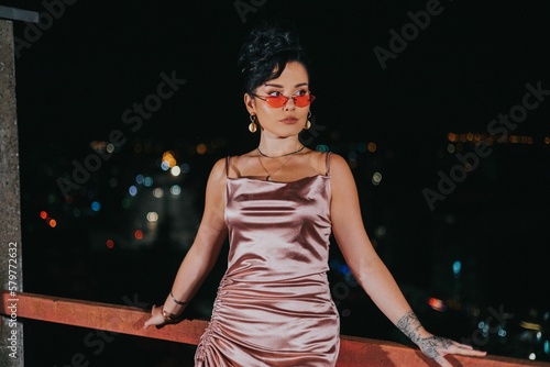 Portrait of a sexy Caucasian white woman in sunglasses on the balcony at night