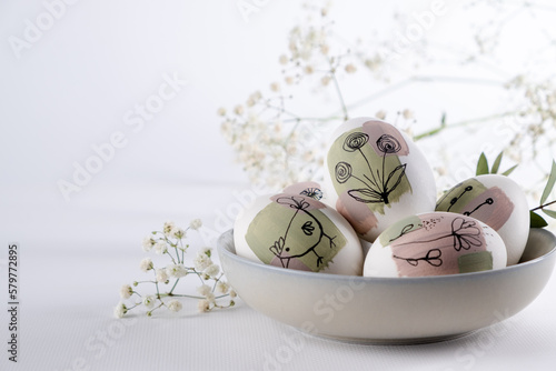 Canvas Print Bowl with modern creative trendy  hand painted easter egg in spring flowers on white background
