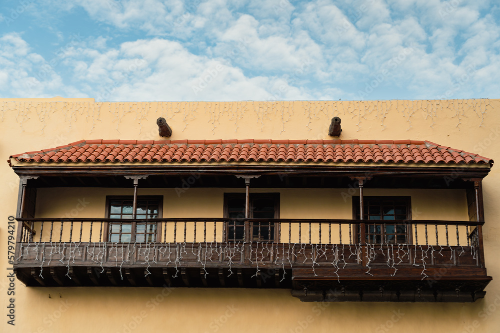 Traditional wooden Canarian balcony in yellow building in old town in the city of Las Palmas de Gran Canaria, Spain