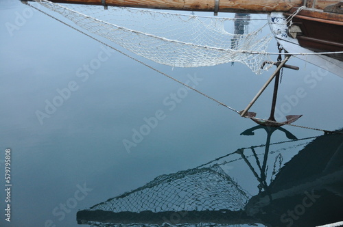 Old Anchor In Water in the morning.. Reflected anchor above the water surface. photo