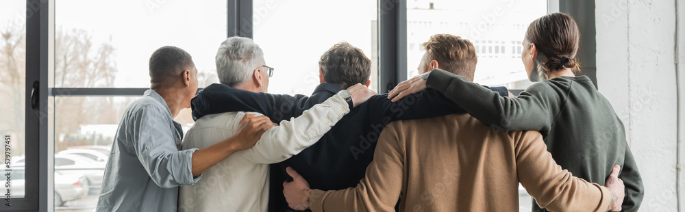 Εκτύπωση καμβά Back view of interracial people hugging during alcoholics meeting in rehab center, banner