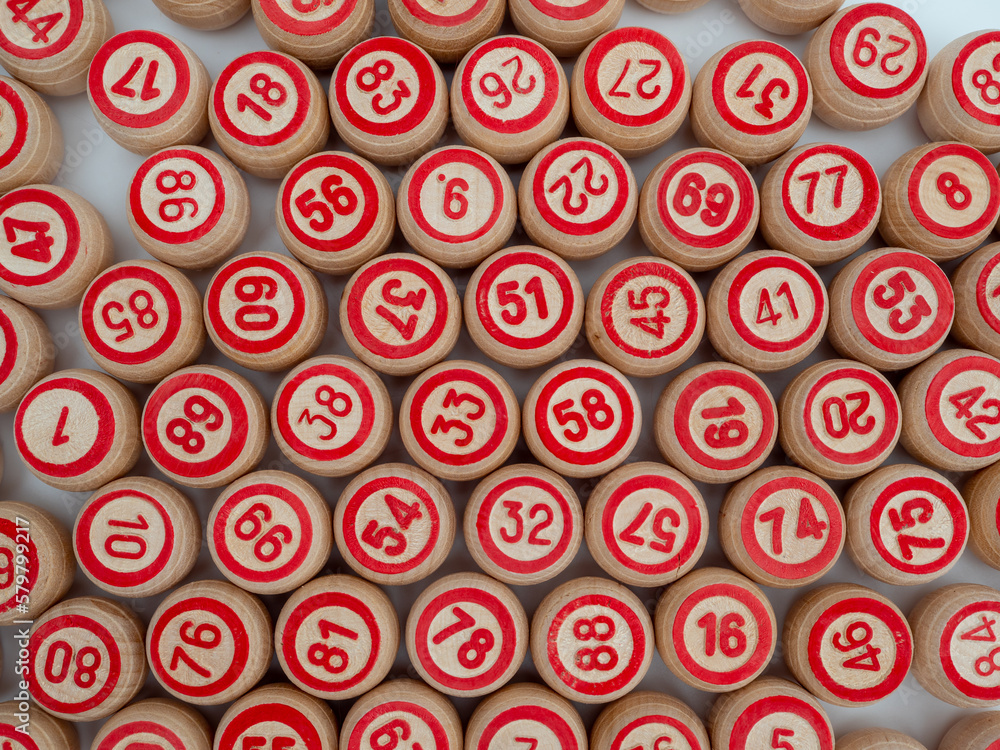 Board game bingo. Wooden barrels with lotto numbers, playing cards for the game. Close-up. Board game bingo. Wooden barrels with lotto numbers, playing cards for the game. Close-up.