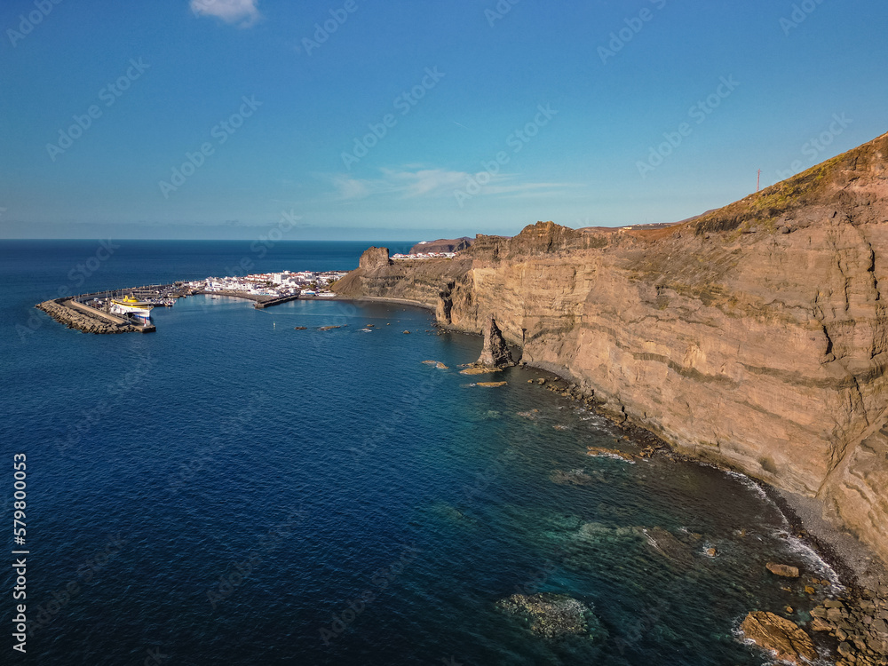 Aerial view of beach and port in traditional whitewashed village, Puerto de las Nieves, Agaete, with cliffs in the northern coast of Gran Canaria, Spain