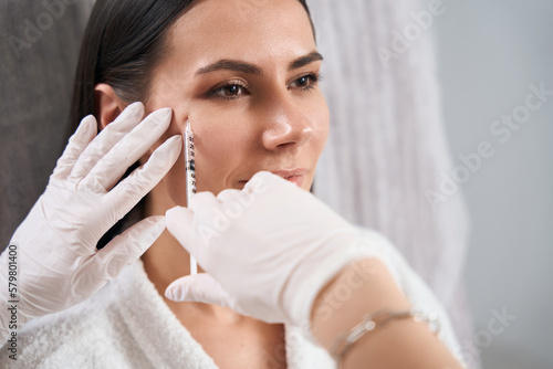 Pretty lady on injection procedure in cosmetology cabinet