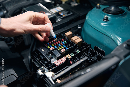 Man inspecting technical condition of car fuse