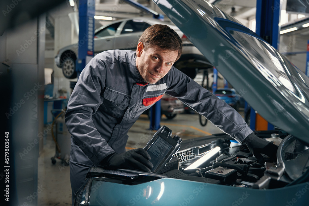 Mechanic in overalls working near the automobile Mechanic in overalls working near the automobile