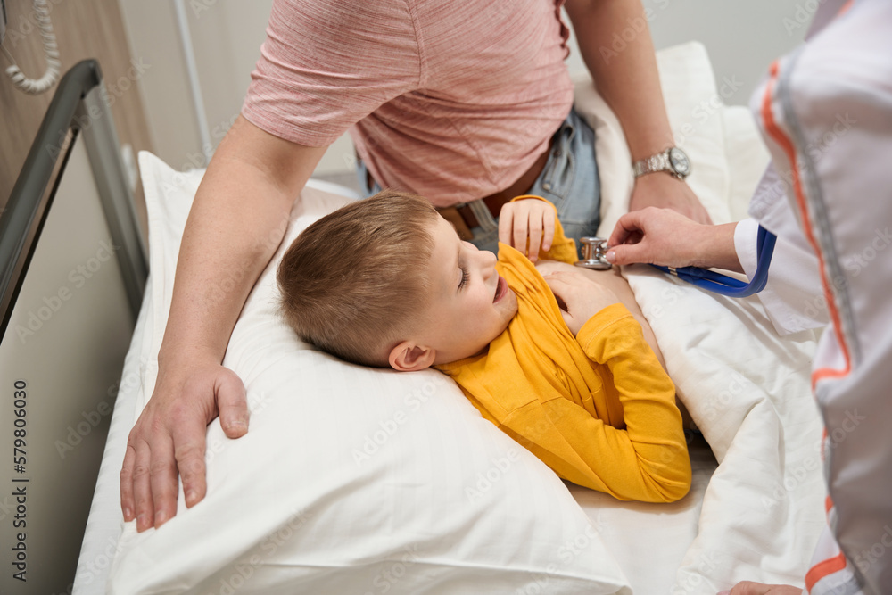 Child receiving qualified consultation with his father in pediatrician clinic Child receiving qualified consultation with his father in pediatrician clinic