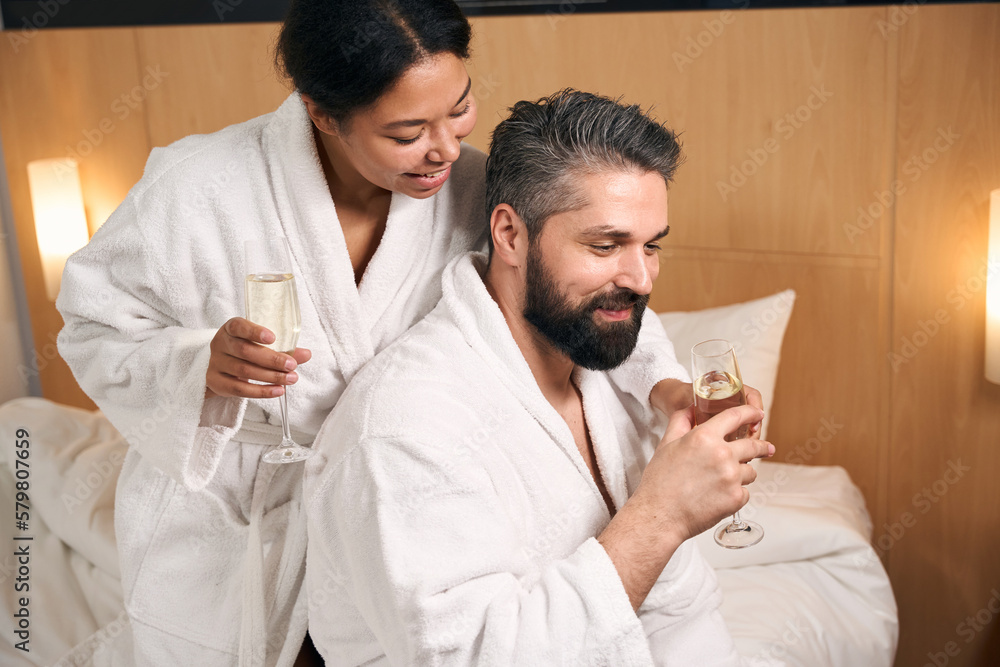 Happy couple drinking to anniversary in hotel room Happy couple drinking to anniversary in hotel room