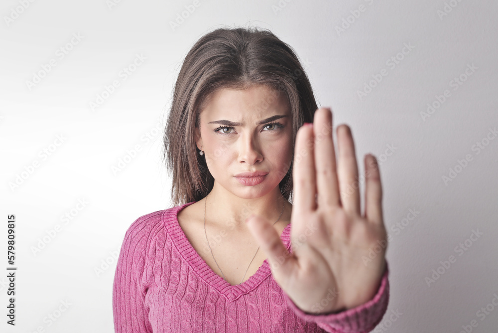 young woman with right hand raised in refusal refuses young woman with right hand raised in refusal refuses
