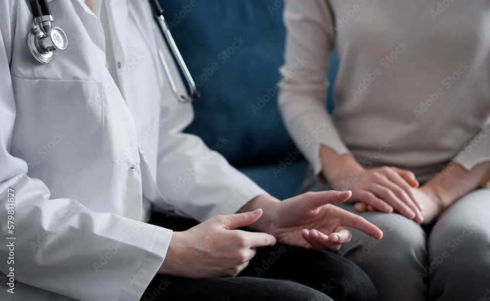 Obraz premium Doctor and patient discussing current health examination while sitting at sofa in clinic office, closeup. Medicine concept.