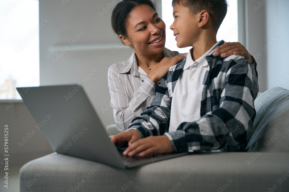Caring mother helps her son in online learning Caring mother helps her son in online learning