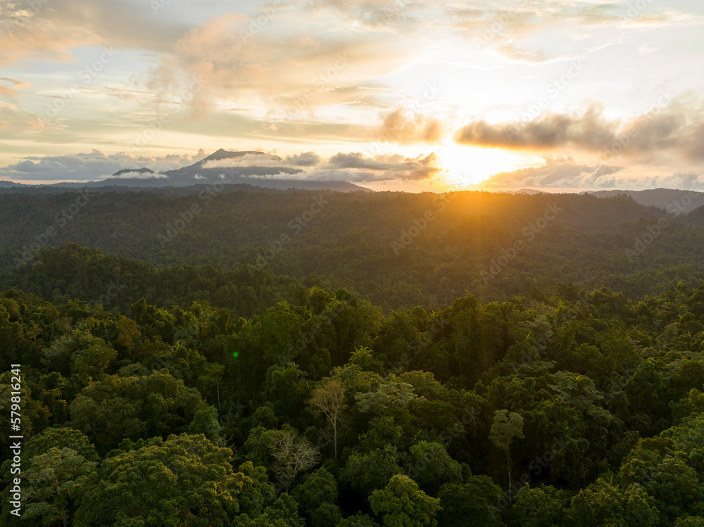 Aerial view of sunset through clouds over jungle in Halmahera, Indonesia. Aerial view of sunset through clouds over jungle in Halmahera, Indonesia.