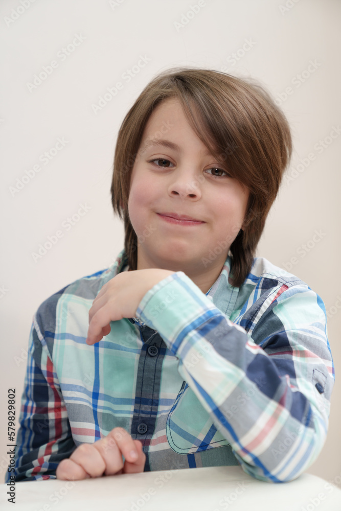 Portrait of friendly white kid waiting for food in a cafe. Cheerful Ukrainian boy sitting behind a table in fastfood restaurant Portrait of friendly white kid waiting for food in a cafe. Cheerful Ukrainian boy sitting behind a table in fastfood restaurant