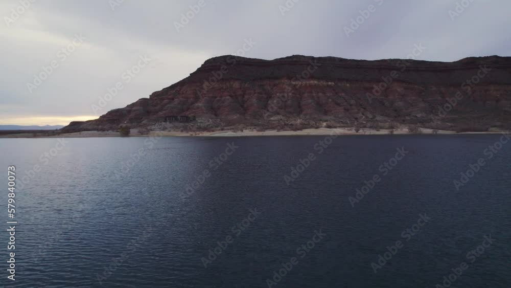 drone shot over lake with red mountains