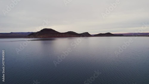 drone fly over lake with red mountains in background