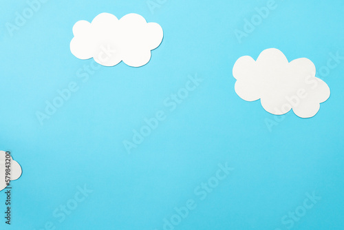 White paper clouds and sky concept on a blue paper, flat lay, top view