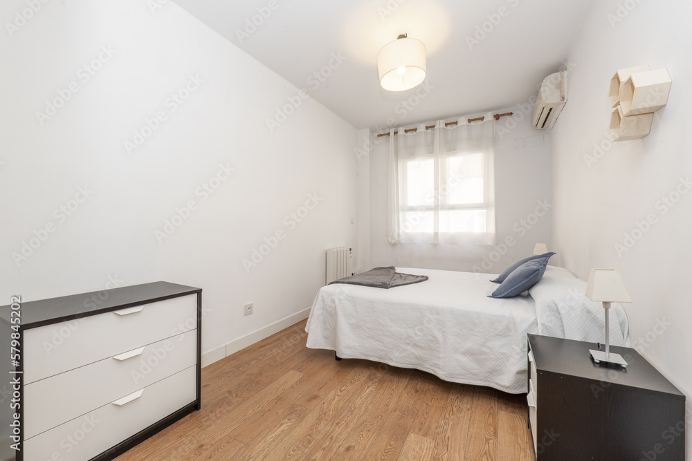 Bedroom with double beds with white bedspread, with wooden floors, double nightstands with drawers and window with curtains Bedroom with double beds with white bedspread, with wooden floors, double nightstands with drawers and window with curtains