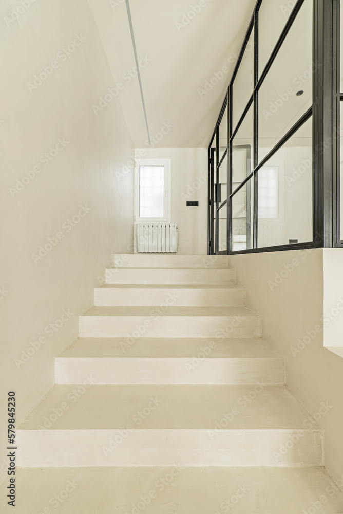 White polished concrete stairs with access to a closed room with metal and glass glazing White polished concrete stairs with access to a closed room with metal and glass glazing