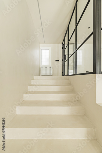 White polished concrete stairs with access to a closed room with metal and glass glazing © Toyakisfoto.photos