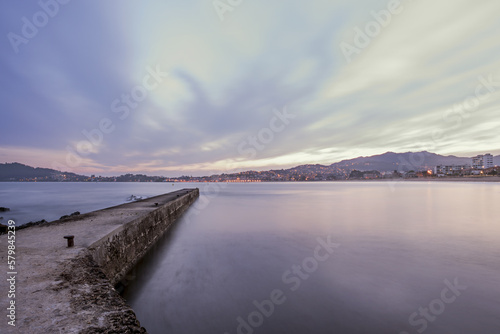 LLong exposure image of a pier at dawn next to a Galician beach © Toyakisfoto.photos