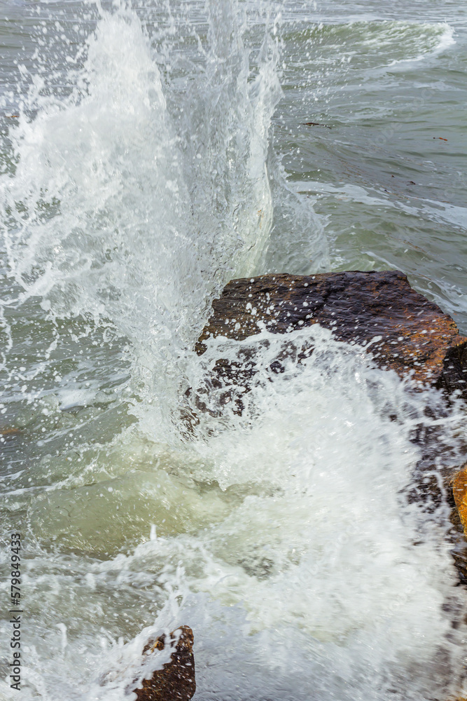 A shot of the sea surf. Splashes of water hitting the stone. Ocean surf among the rocks. Background of the tide. A shot of the sea surf. Splashes of water hitting the stone. Ocean surf among the rocks. Background of the tide.