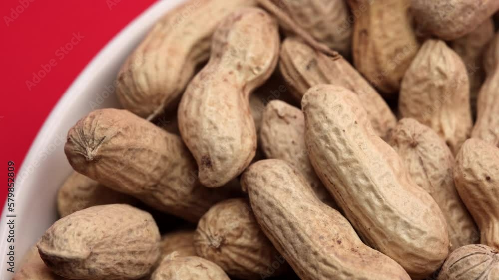Peanuts In White Bowl Cup On Red Background. Dolly Slider Shot. 4k, 60 FPS, ProRes. Peanuts In White Bowl Cup On Red Background. Dolly Slider Shot. 4k, 60 FPS, ProRes.