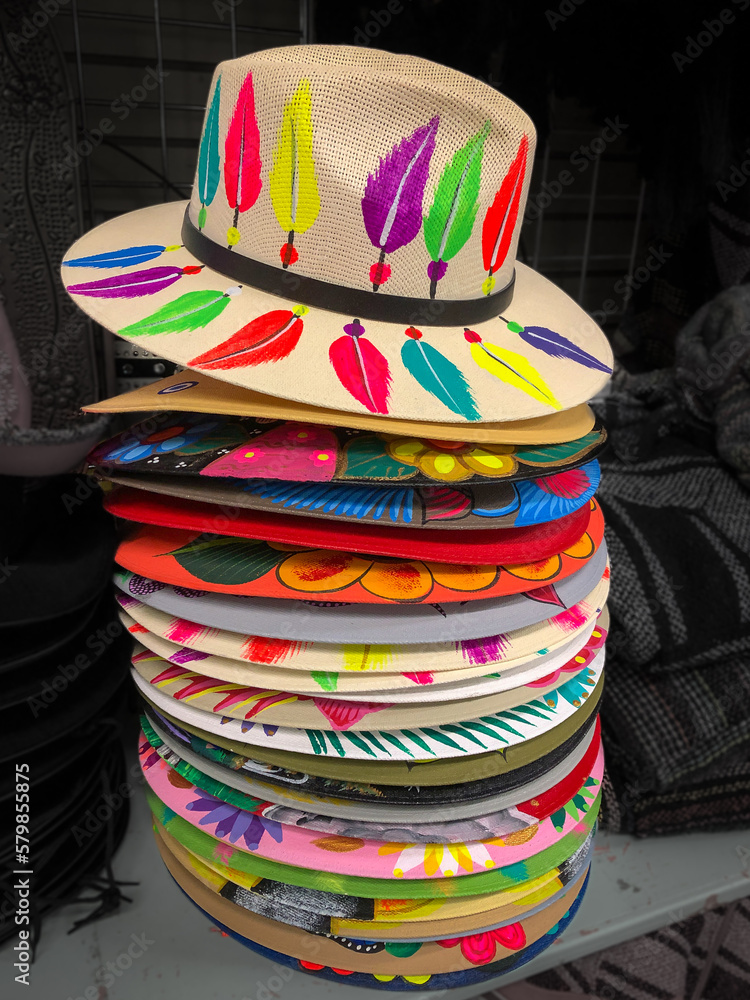 Colorful hats in a vertical stack, on display for sale in a tourist shop with items from Mexico.