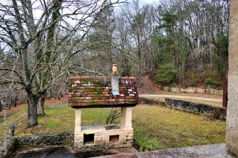 Outdoor barbecue constructed with oak beams, old tiles and stone columns with a woodland backdrop
Outdoor barbecue constructed with oak beams, old tiles and stone columns with a woodland backdrop