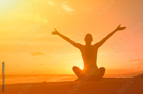 woman enjoying the beautiful sunrise feeling joyful with open arms 