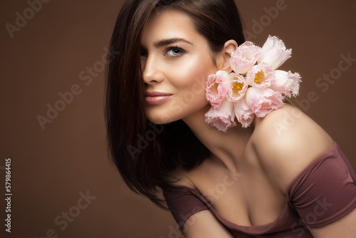 Wallpaper Mural Beauty Girl with natural Makeup and Pink Flowers Bouquet over Brown Background. Woman Face Skin Care and Spa Cosmetology. Fashion Model Portrait with Spring Tulips Torontodigital.ca