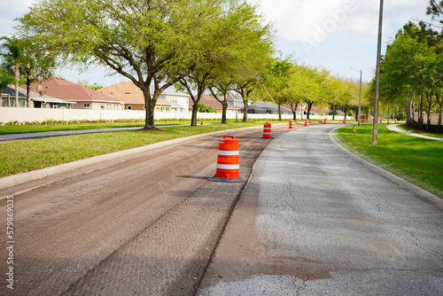 Work on road. Construction cone. Traffic cone, with white and orange stripes on asphalt. Street and traffic signs for signaling. Road maintenance, under construction sign and traffic cone on road photo