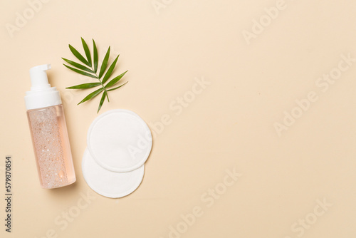 Canvas Print Foaming facial cleanser and with eco pads on color background, top view