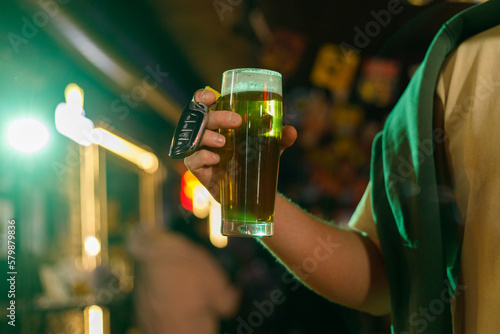 Young man drunk with glass of beer and key in his hand