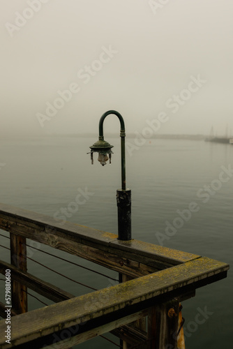 light on pier on harbor in the fog