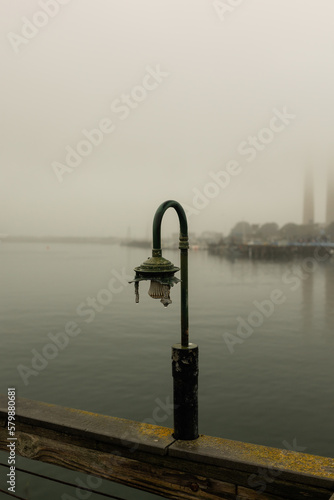 light on pier on the bay in the fog