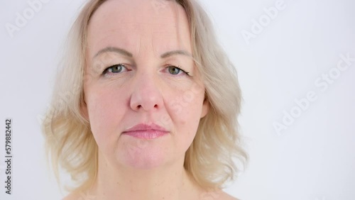 calm sad look of girl adult middle-aged woman on white background looks into frame, only eyes move, she froze Close up of Woman Face, Girl opening her Beautiful blue azzure Eyes, Attractive Ginger photo