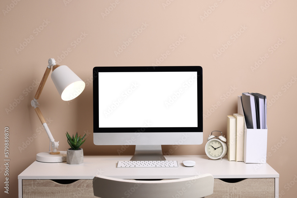 Cozy workspace with computer, lamp, houseplant and stationery on wooden desk Cozy workspace with computer, lamp, houseplant and stationery on wooden desk
